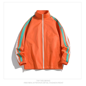 Detail of orange sports jacket showing stand collar and green striped sleeves