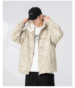 Close-up of khaki hooded jacket featuring white paisley patterns and street style zipper