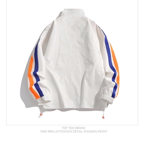 Detail of white windbreaker jacket back featuring blue and orange sleeve stripes