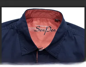 Close-up of contrast collar on navy blue short sleeve shirt with red lining and stitching