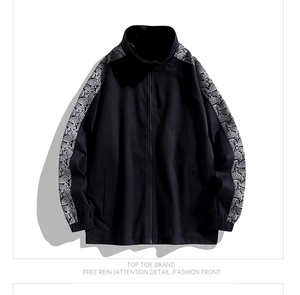 Close-up of the detailed paisley pattern stitching on the sleeve of a black jacket