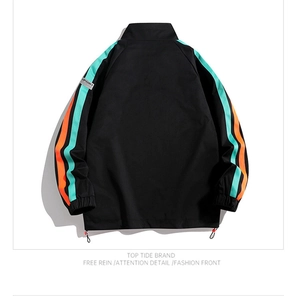 Macro detail of casual black sports jacket showing striped sleeves and elastic cuff design