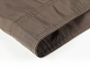 Close-up of the double-stitched hem on a casual brown military-style cotton jacket