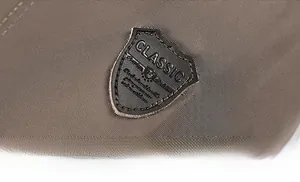 Detail of classic shield leather patch on dark brown military jacket fabric
