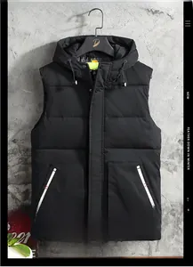 Dettaglio del gilet nero con cappuccio, coulisse e accenti arancioni sulle tasche laterali
