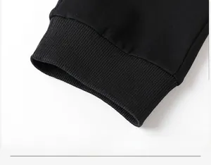 Close-up of black joggers showing elastic ribbed cuffs and high-density knitted fabric