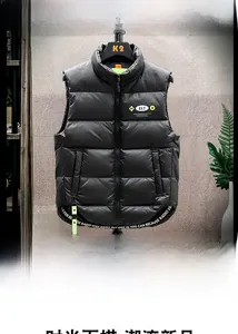 Detail of black down vest featuring standing collar and yellow ELT logo patch
