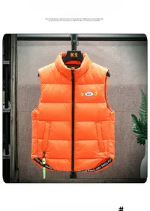 Detailed view of bright orange down vest with stand collar and horizontal quilting