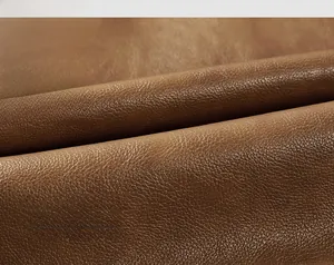 Detail of brown faux leather fabric showing high-quality lychee texture for men jacket