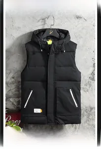 Dettaglio del gilet nero con cappuccio, tessuto antivento e ampie tasche quadrate
