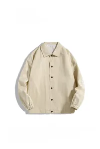 Detail of light beige coach jacket showing black snap buttons and paisley printed sleeves