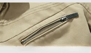 Detailed close-up of khaki cotton twill fabric with metal zipper and precision stitching