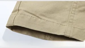 Detailed close-up of double-stitched hem on a khaki cotton jacket with twill texture