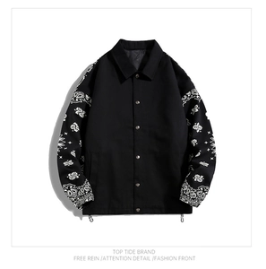 Detail of snap button closure and white paisley pattern on black streetwear jacket sleeves