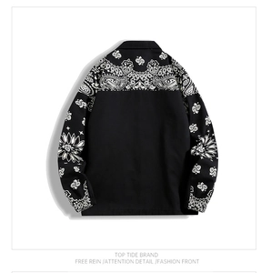 Detail of black streetwear jacket featuring white paisley pattern patchwork on back and shoulders