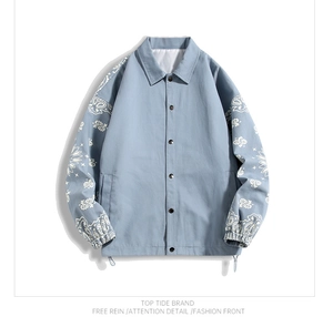 Detail of light blue jacket sleeve showing white paisley pattern print and elastic cuff