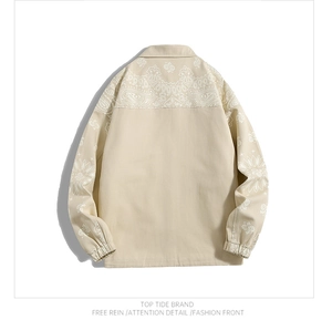 Detail of beige cotton jacket featuring white paisley prints on shoulders and sleeves