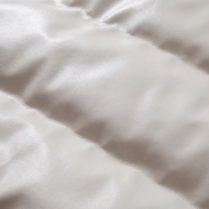Macro shot of horizontal quilted texture on light beige faux leather jacket material