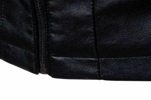 Detailansicht der genarbten schwarzen Lederstruktur und Metall-Reißverschluss der Jacke