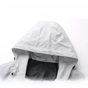 Detail of light grey hooded jacket showing windproof fabric texture and dark patterned lining