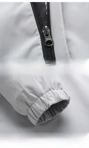 Close-up of durable resin zipper and elastic windproof cuffs on light gray casual jacket