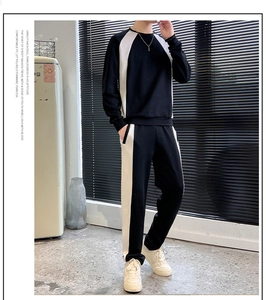 Detail of men's casual two-piece tracksuit featuring white side stripes on black fabric