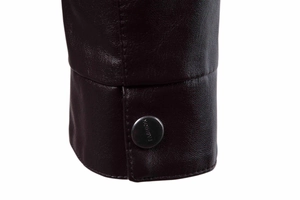 Detailaufnahme des Ärmels einer dunkelbraunen Lederjacke mit einem metallischen Druckknopf