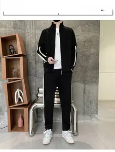 Detail view of black athletic tracksuit featuring side white stripes and stand-up collar