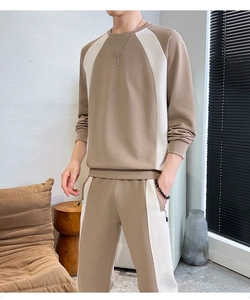 Detail view of men's color-block tracksuit set featuring brown and cream knit panels