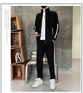 Detail of black men's tracksuit jacket and joggers with stylish beige side stripes