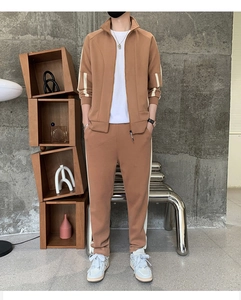 Close-up of brown casual tracksuit set featuring side white stripes and stand collar detail