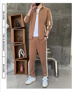 Detail of warm brown men's sports set with white side stripes and stand collar jacket