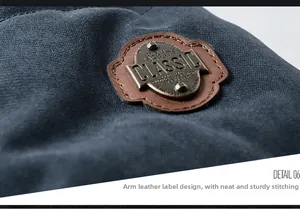 Macro shot of a vintage leather arm patch with embossed metal logo on blue cotton jacket