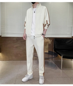 Detail of cream-white track jacket with brown side stripes and stand collar design