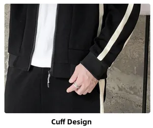 Detail view of ribbed cuffs and metal zipper on black athletic track jacket with stripes