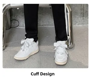 Detailed view of white platform sneakers paired with black striped athletic joggers