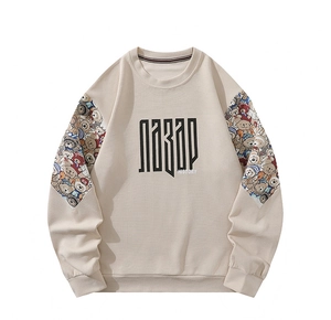 Détail du tissu gaufré et du patchwork d'ours de dessin animé sur sweat beige
