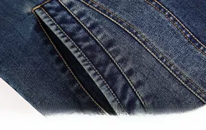 Detail of single-breasted denim jacket showing pocket stitching and orange thread