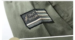 Detailed macro view of black embroidered outdoor patch on army green shirt sleeve