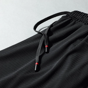 Men's black breathable mesh athletic shorts with elastic waistband and drawstring detail