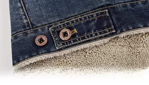 Detailed view of dark blue denim jacket hem featuring warm white faux fur lining