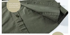Detail of reinforced double stitching and vintage button on green cotton shirt