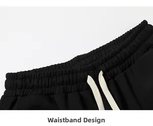Détail d'un pantalon de sport noir avec taille élastique et cordon de serrage blanc cassé