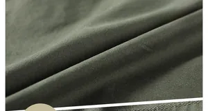 Detailed macro texture of dark green soft fabric showing high-quality woven patterns