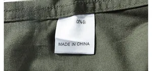 Detail of olive green 100% cotton fabric with flat weave texture and care label