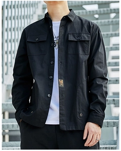 Detail of black workwear shirt featuring large flap pockets and a small yellow MDTS woven label