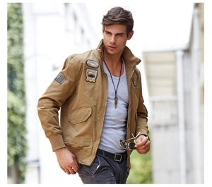 Detailed embroidery patches on the sleeve of a khaki military style cargo bomber jacket