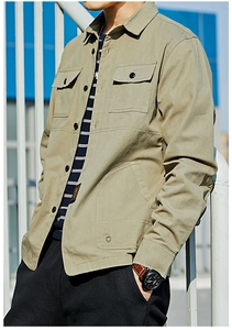 Detailed view of olive green cargo shirt features including chest pockets and woven labels