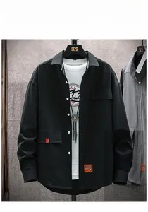 Detail of black long-sleeve cargo shirt with orange DESIGN label and utility pockets