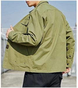 Close-up of military green utility shirt jacket featuring buttoned pockets and canvas texture